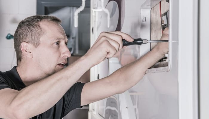 man fixing domestic RV Refrigerator
