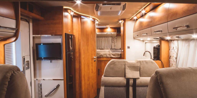 An interior of an Rv that has wooden panels and claddin